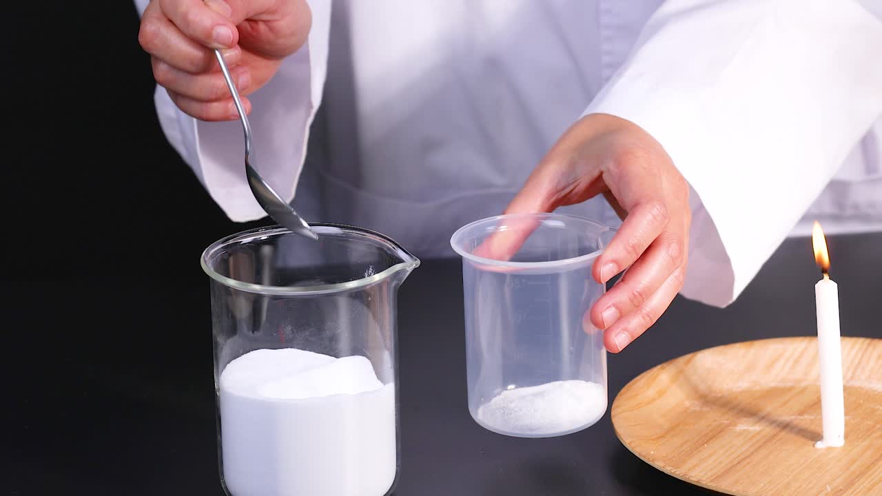 과학자가 실험실에서 불타는 불 근처에서 베이킹 소다와 식초를 사용하여 화학 반응을 수행합니다.