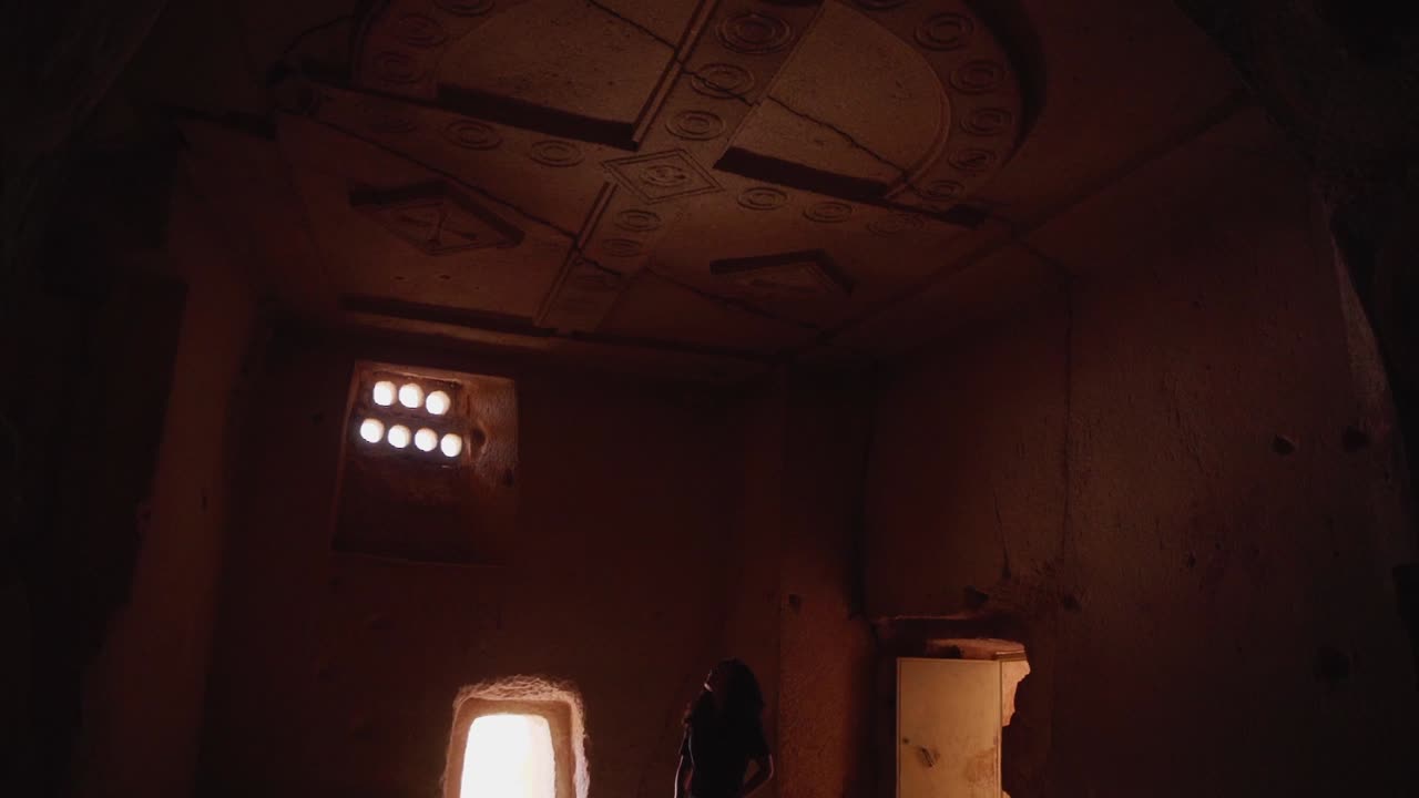 persona echando un vistazo dentro de una antigua casa cueva en capadocia, turquía