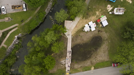 aerial view of people walking on promenade near sager creek in downtown siloam springs