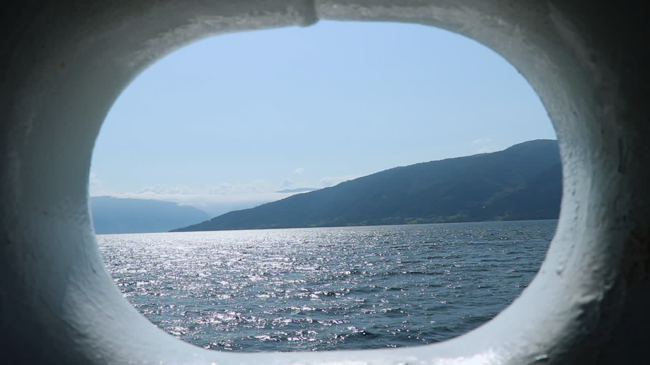 Artistic view of a fiord through a hole of a boat