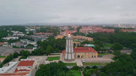 maritime beacon lighting seaside town under cloudy sky drone. coastal lighthouse