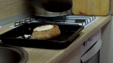 el cocinero toma el khachapuri con la espátula del pastel y lo pone a bordo.