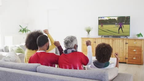 video of african american family sitting on sofa and watching football at home