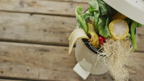 Video-of-white-compost-bin-with-organic-waste-and-copy-space-on-wooden-background