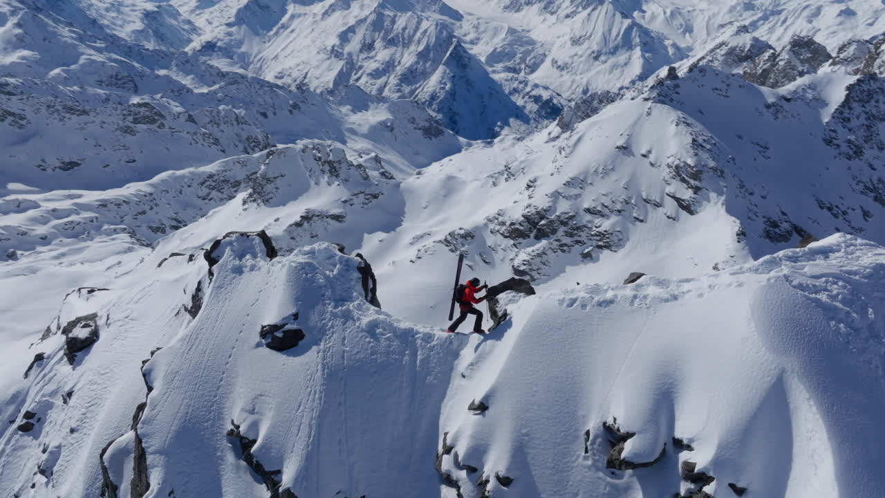 A professional skier hikes up a steep ridge in Verbier, then drops into an epic freeride descent. Pure adventure skiing in deep snow, dramatic terrain, and breathtaking alpine scenery.