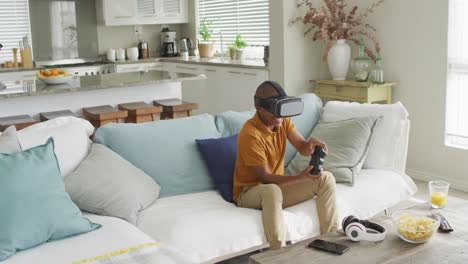 video of happy african american boy using vr headset and playing video games at home