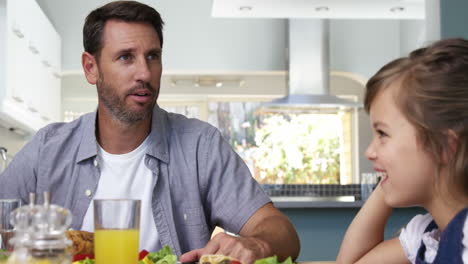 padre e hija hablando juntos durante el almuerzo