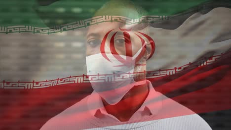 Animation-Der-Iranischen-Flagge,-Die-Während-Der-Covid-19-Pandemie-über-Einem-Mann-Mit-Gesichtsmaske-Winkt