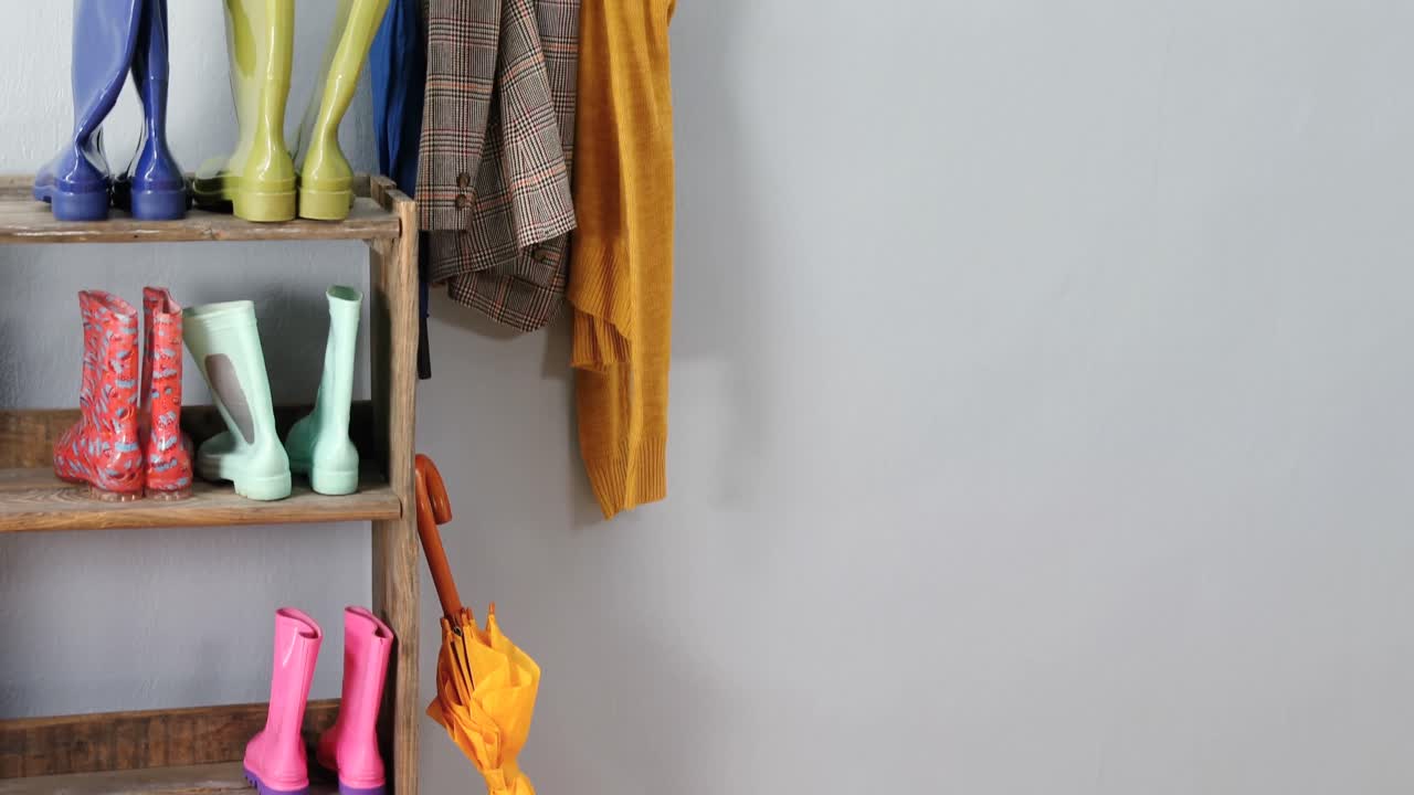 paraguas, blazer, jumper y botas wellington en el estante de zapatos 4k