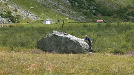 photographer on a rock taking photographs with a tripod