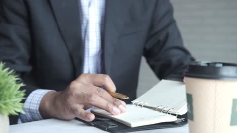 hombre de negocios tomando notas en una cafetería
