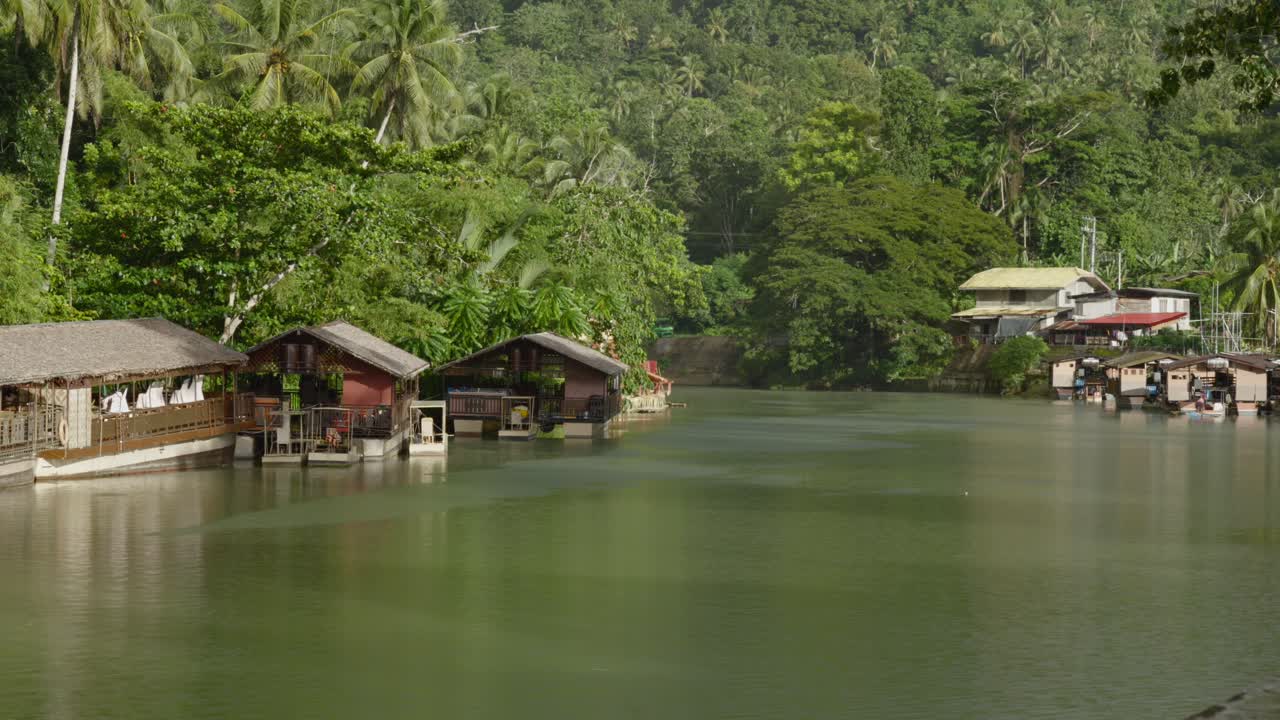 cabañas a la orilla del río enclavadas en la exuberante vegetación a lo largo del tranquilo río loboc en filipinas