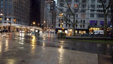 Toma-Ralentizada-De-La-6ta-Avenida-Desde-La-Intersección-Con-Central-Park-Observando-Los-Semáforos-Durante-Una-Tarde-Lluviosa-En-Nueva-York.