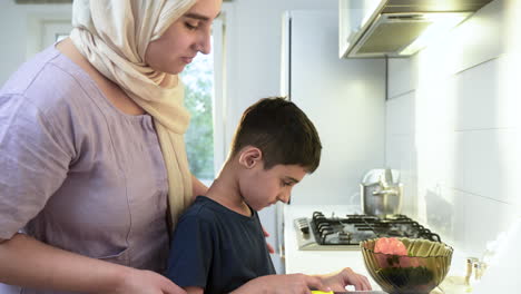 Vista-De-Cerca-De-La-Madre-Con-Hiyab-Y-Su-Hijo-En-La-Cocina.