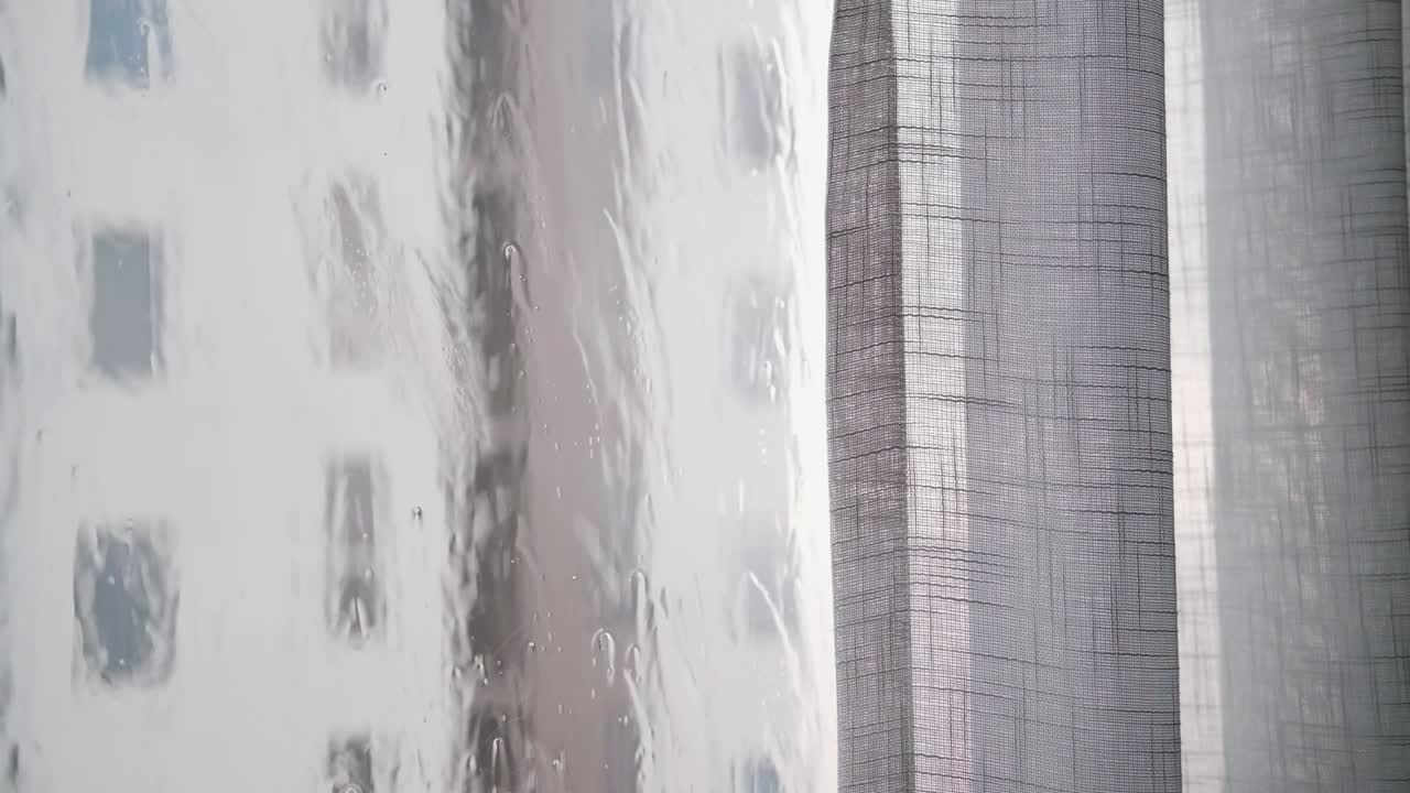 The rain was falling and water splashed on the window. with sheer curtains beside 4k