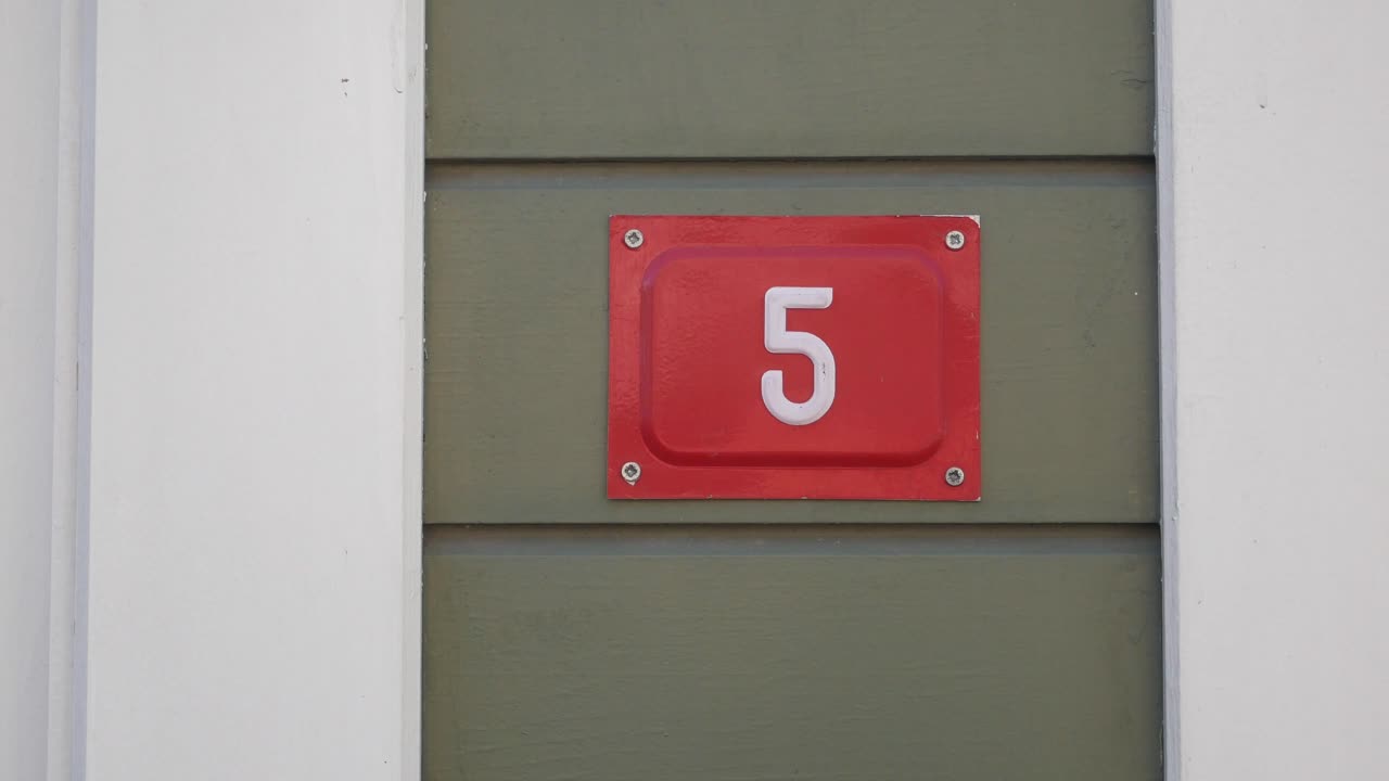 Red Sign with Number 5 on a Green Wall