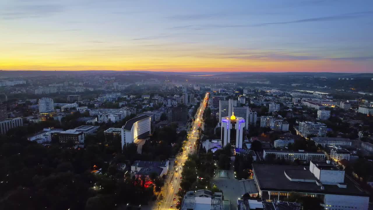 Aerial drone view of Chisinau at evening, Moldova. View of city centre with presidency and parliament, multiple buildings, roads, illumination