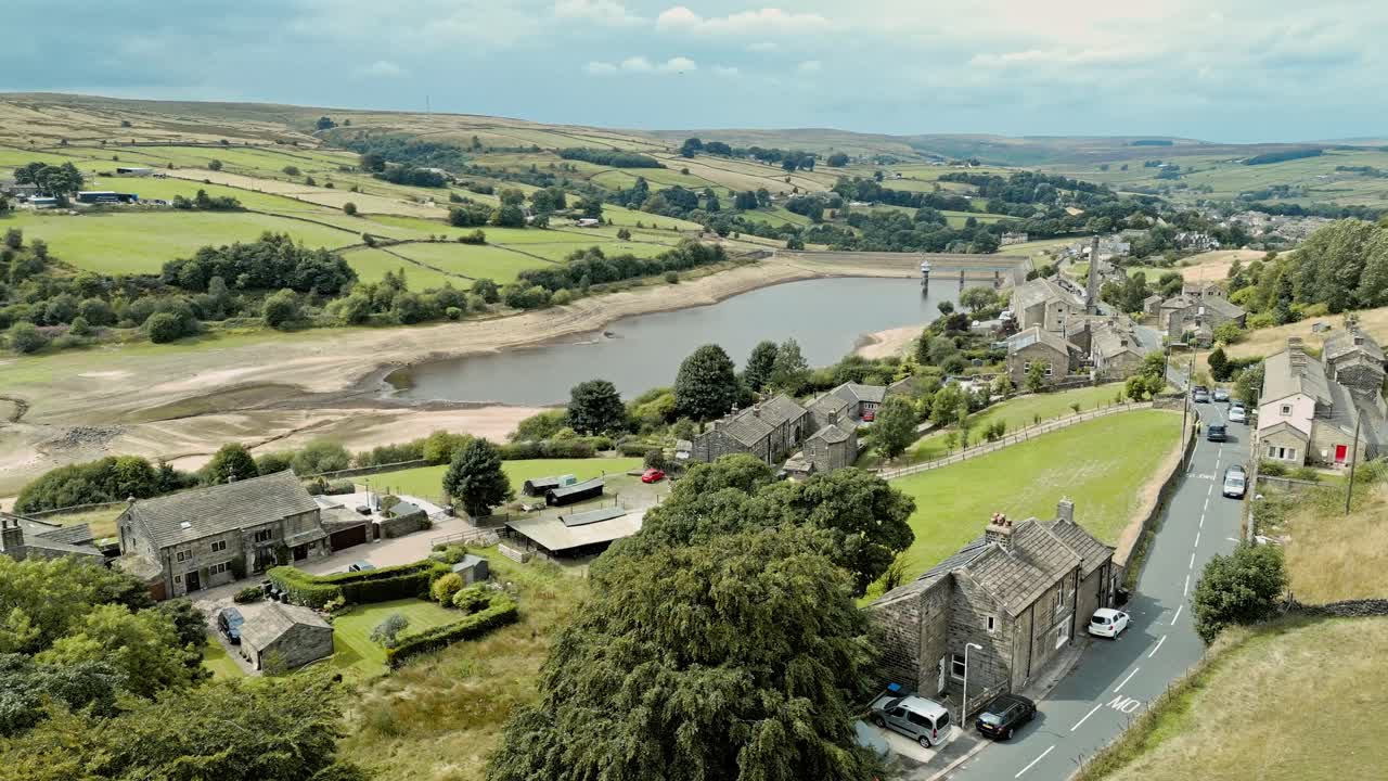 들판과 농지로 둘러싸인 오래된 방앗간과 굴뚝 더미가 있는 시골 산업 마을의 항공 영상