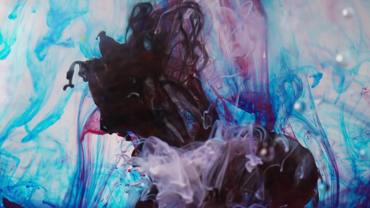 Vivid ink swirling in water creates a colorful and abstract pattern
