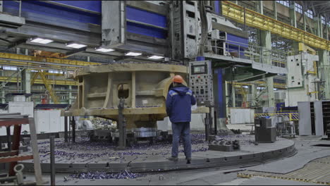 industrial machine operator working on large metal part