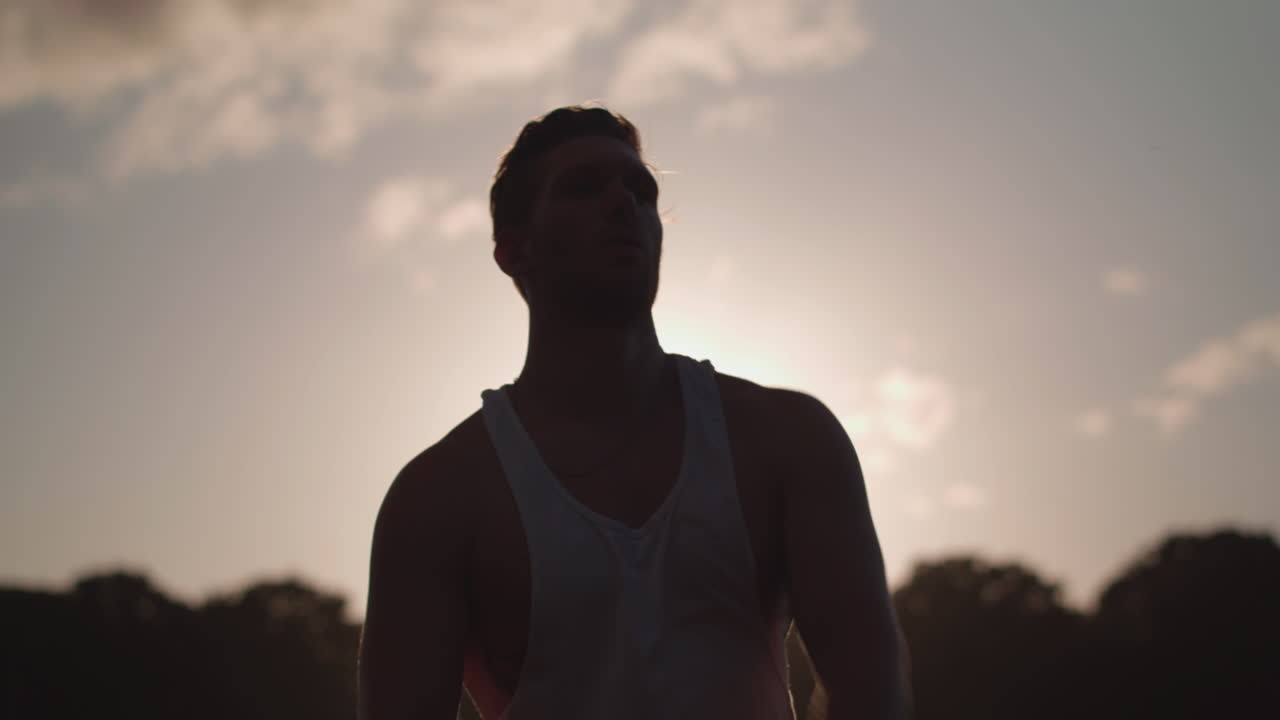 jovem atraente, estendendo-se no parque antes de malhar