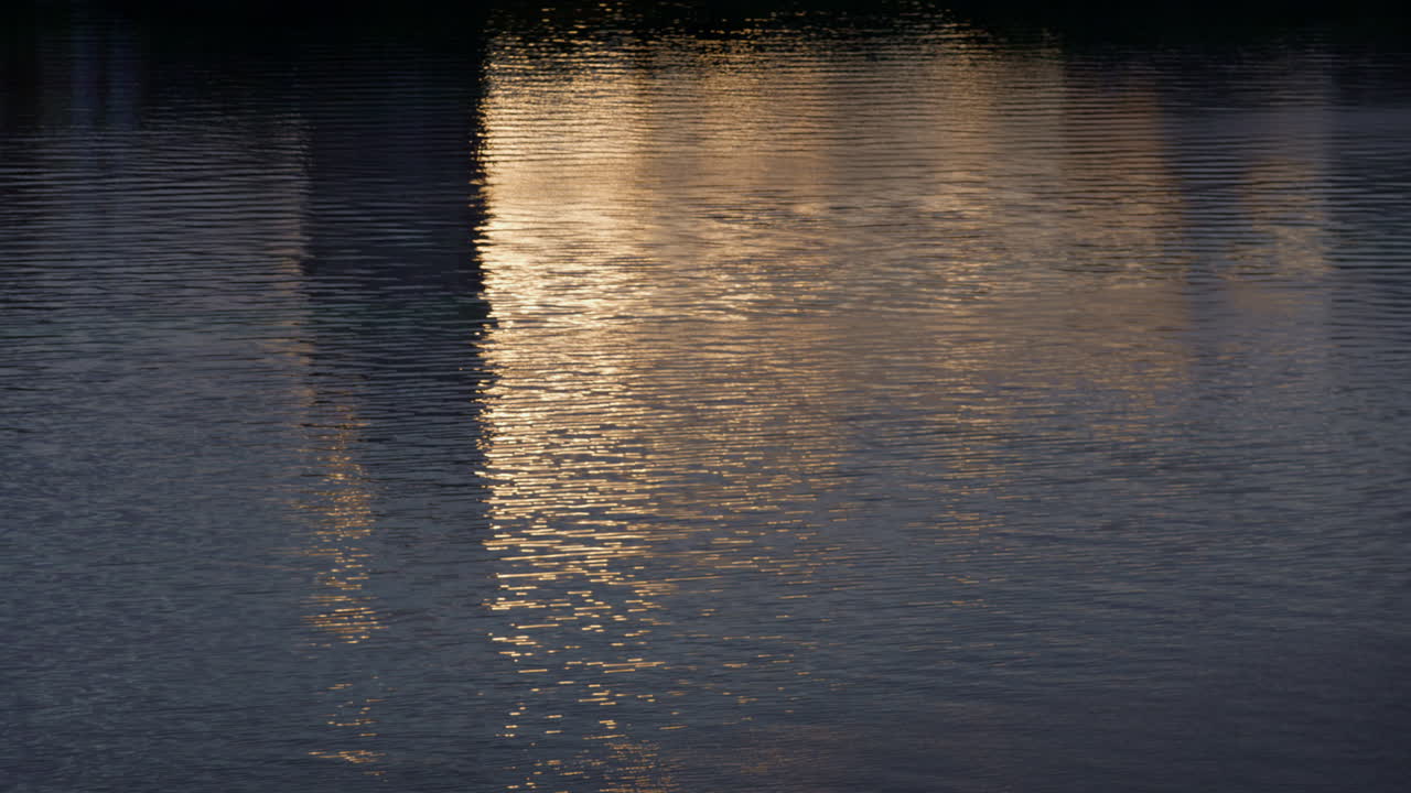 Rippled river water flowing at calm pace drone shot. Glaring waterway surface.