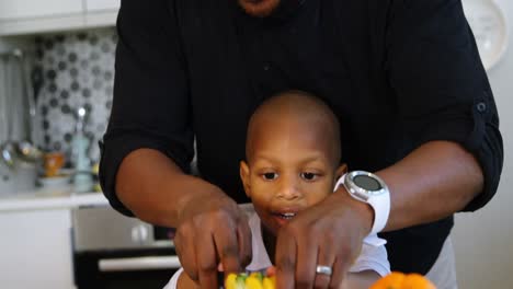 Father-and-son-chopping-vegetables-in-kitchen-at-home-4k