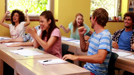estudiantes sentados en el aula y animando