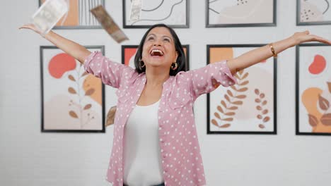 mujer india arrojando dinero al aire