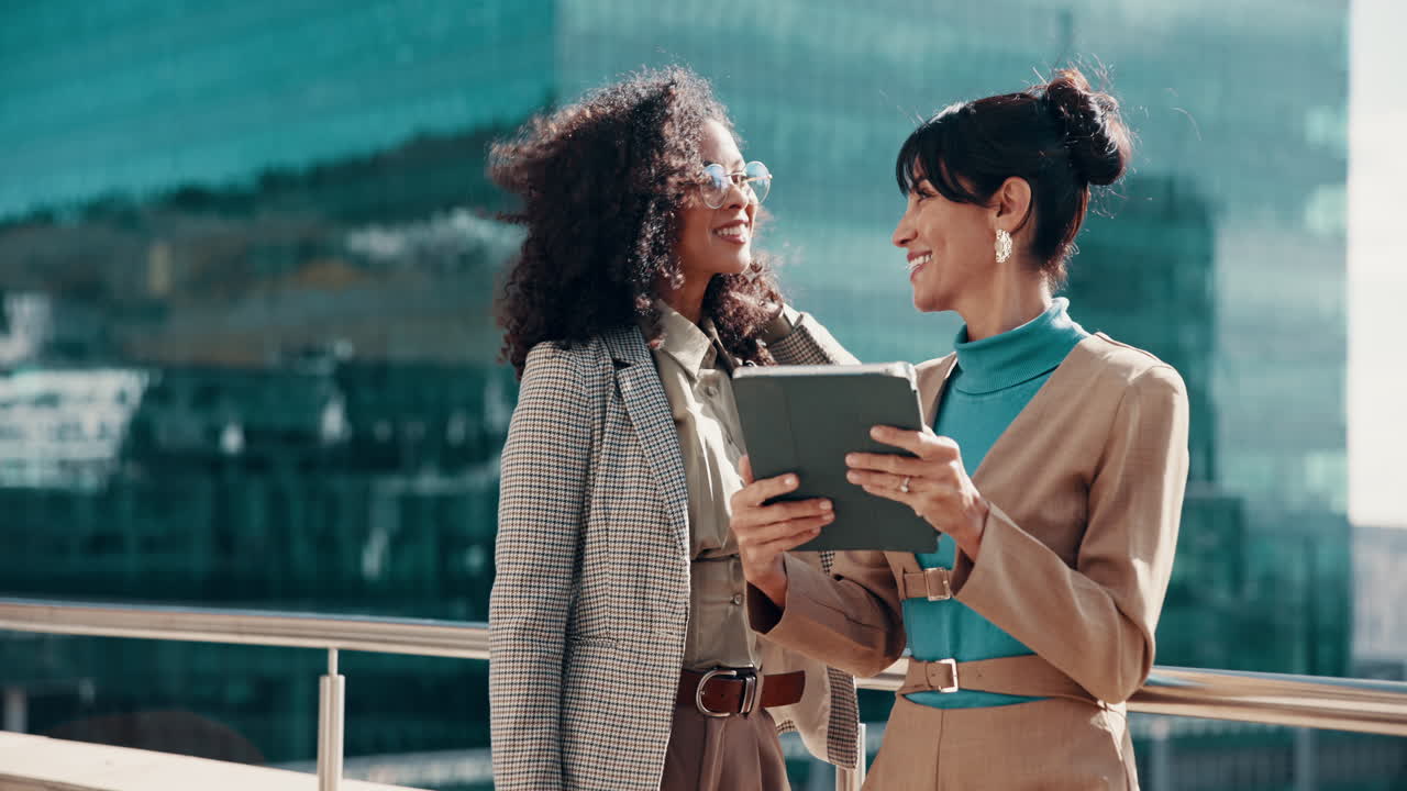 Successful Businesswomen Celebrating with a Tablet Outside a Modern Building