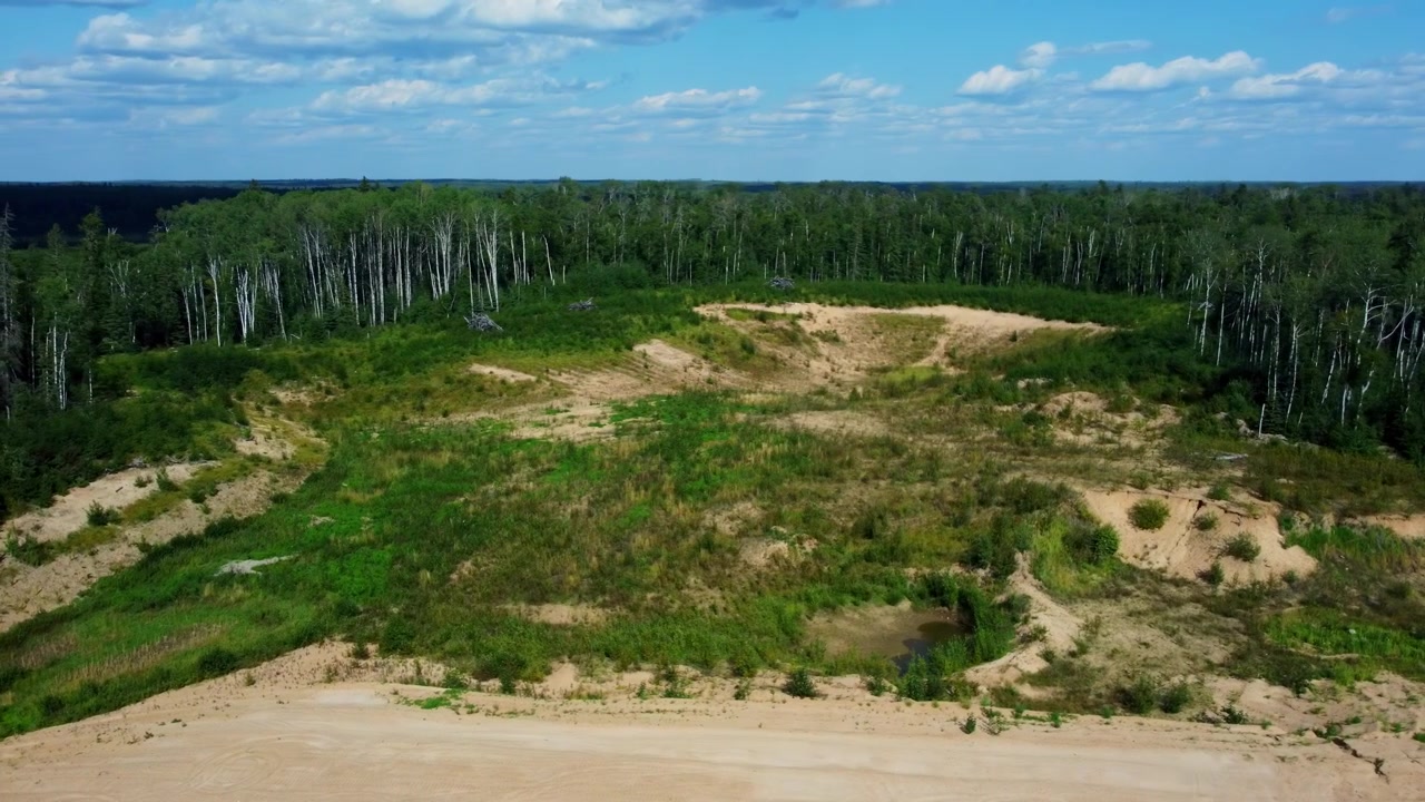 Vista aerea di una cava di sabbia circondata da una fitta foresta in Alberta
