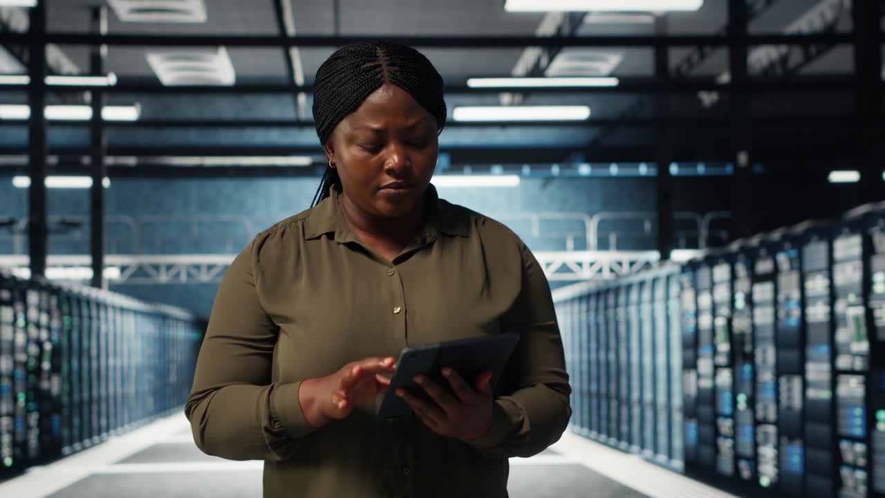 Data center engineer monitors data center metrics on tablet