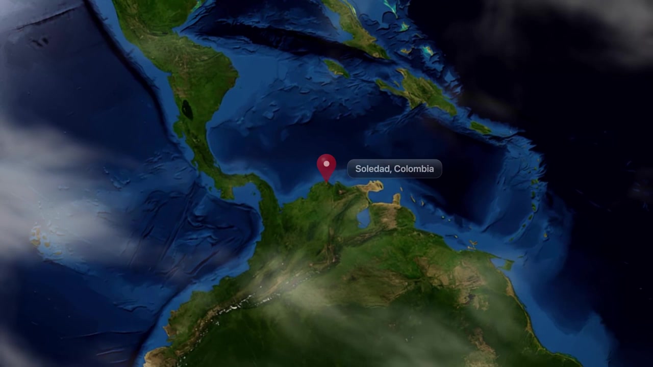 Satellite animation zooms from deep space into planet Earth, pinpointing Soledad, Colombia with a marker. Includes NASA public domain imagery.