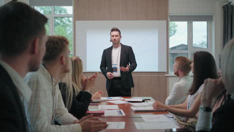 charismatic positive man is speaking in business conference audience is cheering him expert and coach