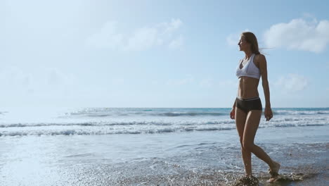 mujer joven caminando por la playa