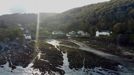 Luftdrohnenumlaufbahn-Einer-Küstenstadt-In-Einem-Tal-Mit-Blendenfleck-Von-Einer-Tiefstehenden-Sonne-Zur-Goldenen-Stunde---Lee-Bay,-Strand,-Ilfracombe,-Devon,-England