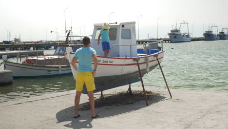 Father-with-cell-making-photo-of-son-in-boat