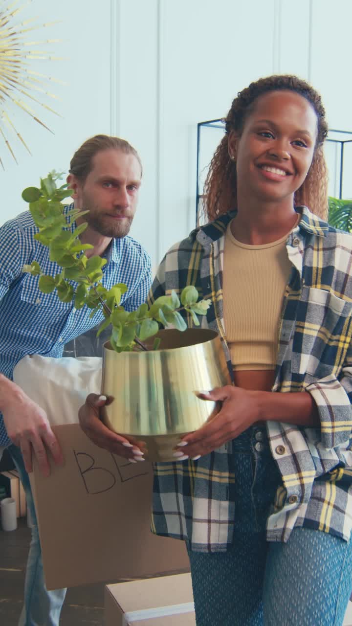 Diverse couple moving into a new home with plants and boxes