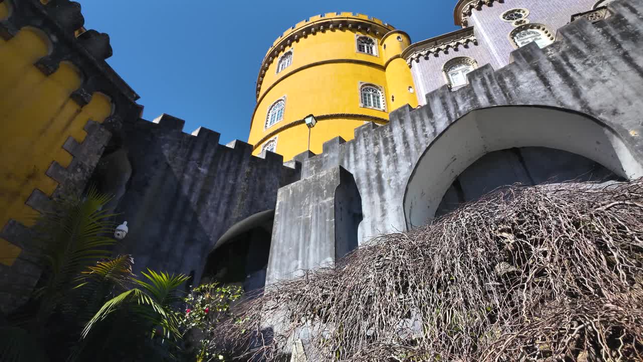 Slowmotion pan of Pena Palace’s vibrant yellow tower in Sintra