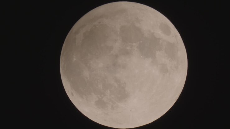Uma lua cheia transita lentamente para cima através do quadro.