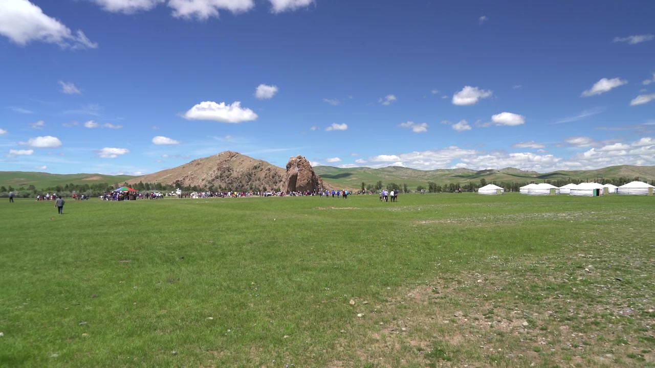 Gruppo di persone riunite su un vasto prato verde in Mongolia