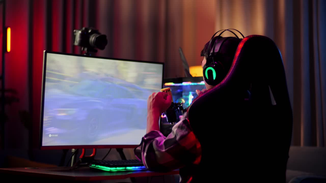 vista trasera de streamer chico asiático gritando gol y bailando celebrando ganando juego de carreras de coches a través de la red en computadora personal. videojuego de transmisión en vivo, escritorio iluminado por rgb led strip light