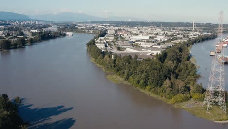 aerial fly over an island indangered wild life in the midst of big industry import export harbor for freighters barges cargo for natural resources hemp lumber produce canibas a river ocean connect 3-3