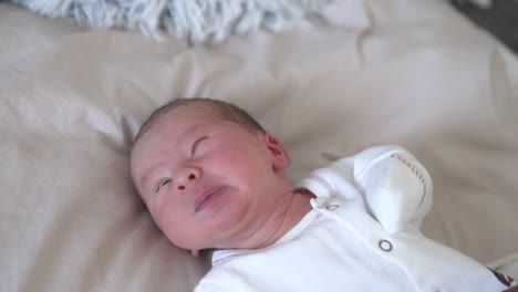 cute baby boy yawning. newborn child laying on a bed and yawning. adorable caucasian baby son.