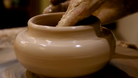 el alfarero está haciendo una olla de arcilla en la rueda del alfarero