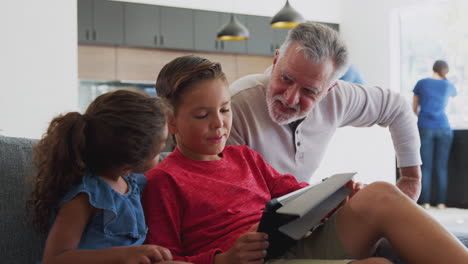 Abuelo-Jugando-Videojuegos-Con-Nietos-En-Una-Tableta-Digital-En-Casa