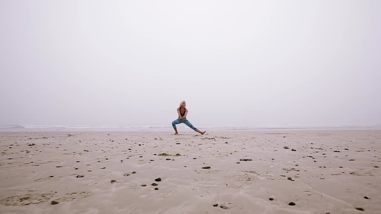 해변에서 스트레칭하는 여성의 전면 모습