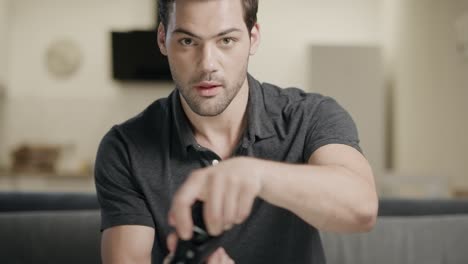 Young-man-playing-video-game.-Concentrated-guy-taking-joystick-at-open-kitchen.