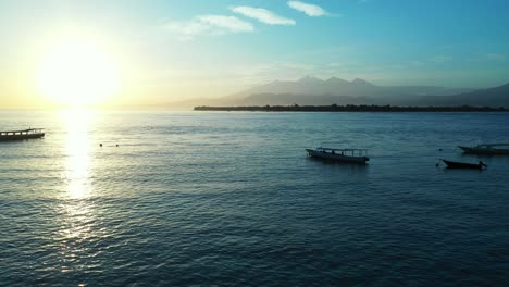 Espectacular-Y-Perfecta-Puesta-De-Sol-En-El-Mar-Con-Barcos,-Isla-En-El-Horizonte,-Amplio-Panorama-Aéreo