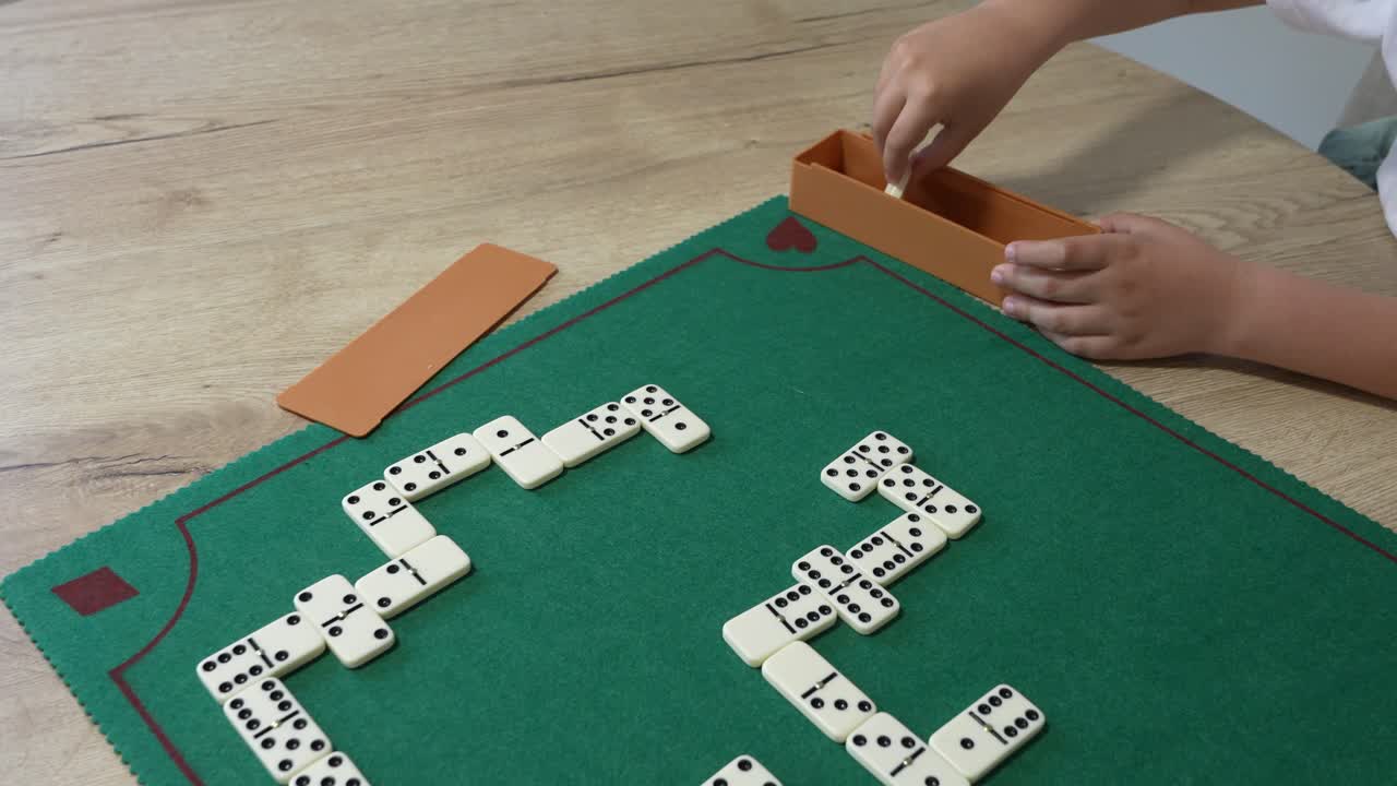 Un bambino gioca a domino su un tavolo